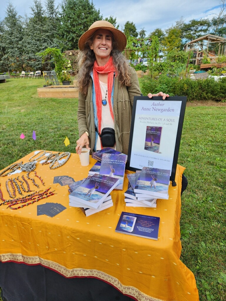 Anne Newgarden standing behind a table of books at Art in the Garden