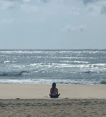 A person meditating on the beach