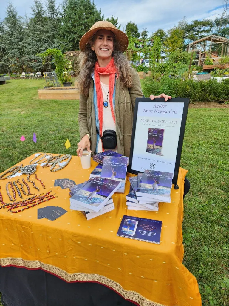 Anne Newgarden standing behind a table of books at Art in the Garden