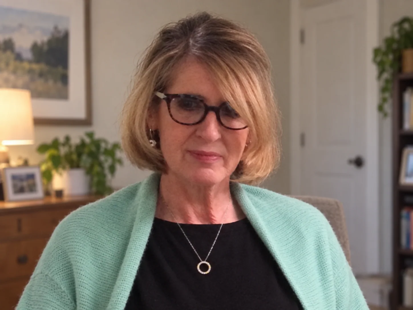 Soul Salon member wearing glasses and a mint-green cardigan