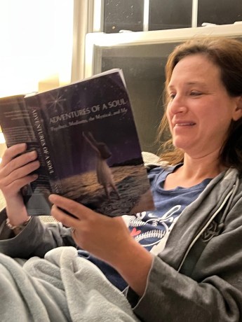 A woman holding a copy of Adventures of a Soul