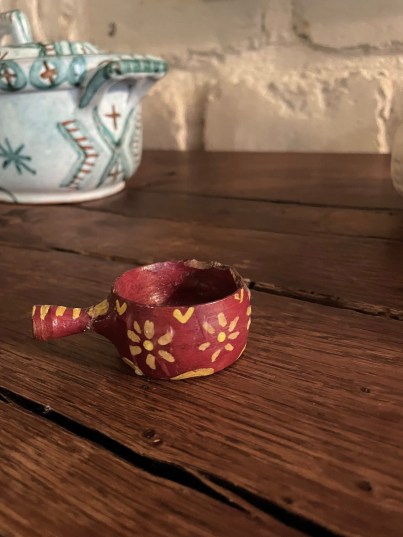 A small red ceramic cup made by Anne’s friend’s sister as a girl