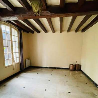 An empty room with exposed ceiling beams in the family home
