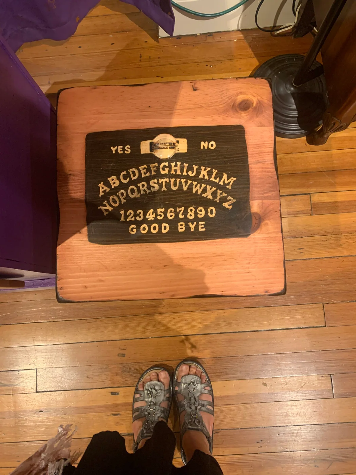 Ouija board and planchette on a wooden table at LightClub Curiosity Shoppe